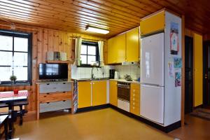 希塞里贝克Holiday Home Långberget的厨房配有黄色橱柜和白色冰箱