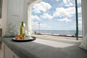 彭赞斯Sophia's的一张桌子,上面有盘子食物,还有一个窗口,享有海滩美景