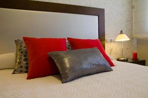 波多诺伏APARTAMENTOS DE CANELAS SUITES con AMPLIAS TERRAZAS的一张红色和红色枕头的床