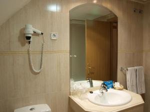 马德里唐路易酒店的一间带水槽、镜子和卫生间的浴室