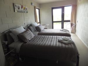 奥托罗杭阿怀托摩高尔夫住宿加早餐酒店的一间卧室设有两张床和窗户。