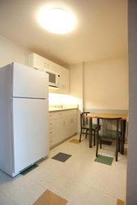 巴里公寓及会议中心酒店 - 巴里的厨房配有白色冰箱和桌椅