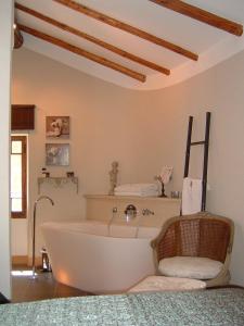 艾日杜维莱治迪兹套房酒店的一个带椅子的房间内的白色浴缸