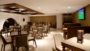得土安A44酒店的餐厅设有桌椅和平面电视。