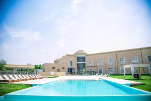 玛利亚镇阿梅里安玛丽亚公园酒店的一座带椅子的建筑前的游泳池