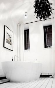 博赫尼亚Regis Residence的带2扇窗户的浴室内的白色浴缸