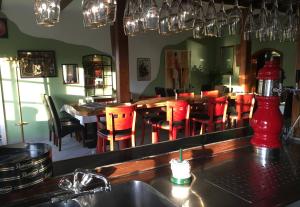 博克霍恩佐尔布彻酒店的餐厅设有酒吧,配有红色椅子和镜子