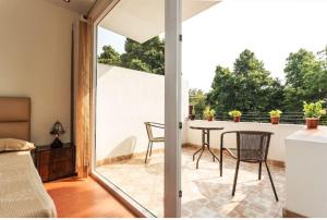 新德里纪念碑宁静公寓的客房设有带桌椅的庭院。