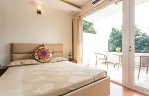 新德里纪念碑宁静公寓的一间卧室设有一张床和一个滑动玻璃门