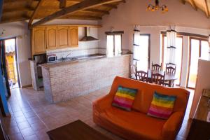 VallecilloCasarural Vallecillo的一间带橙色沙发的客厅和一间厨房