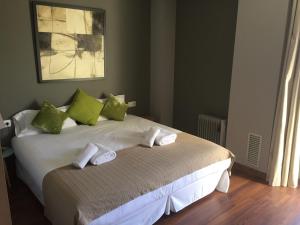 略夫雷加特河畔奥斯皮塔莱特FIRA巴塞罗那公寓的一间卧室配有带绿色和白色枕头的床