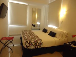 卡塔赫纳萨尔梅迪纳酒店的酒店客房配有带白色床单和枕头的床。