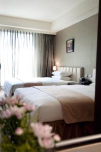 高雄高雄商旅的酒店客房设有两张床和窗户。