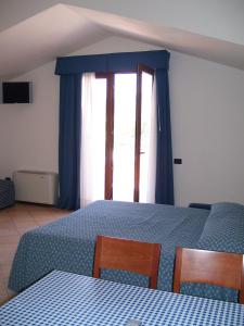 博萨伊索拉罗萨酒店的一间卧室设有蓝色的床和窗户。