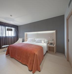 塔法利亚塞尔科蒂尔霍拉塔法拉酒店的一间卧室配有一张带橙色毯子的大床