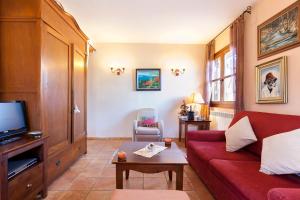 塞尔瓦堡Casa Las Tinajas的客厅配有红色沙发和电视