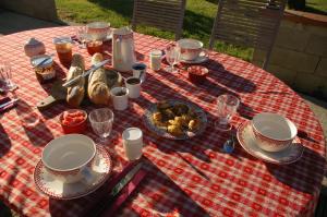 Thil梅侬农场酒店的一张野餐桌,上面有食物,放在红色和白色的桌布上