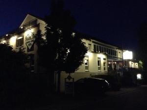赖恩海姆苏尼贝尔旅馆的白色的建筑,在晚上有棵树在前面