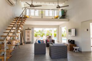 棕榈滩Malmok Beach Break Villa的一间带楼梯和沙发的客厅