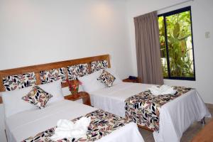 伊基托斯Hotel Jungle House的酒店客房设有两张床和窗户。