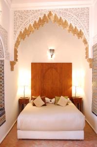 拉巴特达尔索珐酒店的卧室配有一张白色大床和木制床头板