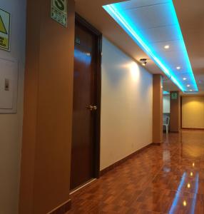 胡利亚卡套房之家酒店的一条空的走廊,有门和蓝色的灯光