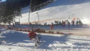 莫济列Apartmaji Golob-Golte的坐在雪地里滑雪缆车上的人