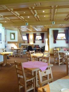 夏蒙尼-勃朗峰奥斯塔雷酒店的用餐室配有木桌和椅子