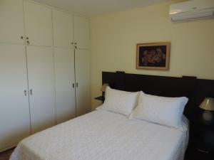 蒙得维的亚Marazul的卧室配有白色的床和白色橱柜。