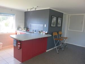 怀希比奇阿塔拉亚公寓的厨房配有红色和蓝色的台面和椅子