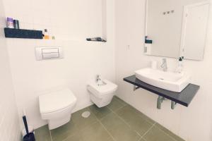 阿利坎特Modern Apartment - Alicante的白色的浴室设有卫生间和水槽。