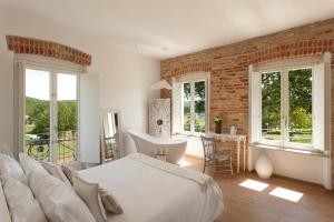 内伊韦朗格乡村别墅住宿加早餐旅馆的卧室配有白色的床和砖墙