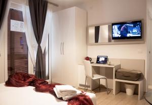科莫科莫罗索维诺酒店 的一间卧室配有一张床、一张书桌和一台电视