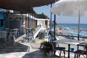 德瓦玛丽娜巴尼阿尔科巴里诺酒店的一个带桌椅的庭院和海滩