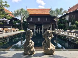 清迈Villa Mahabhirom - SHA Plus的两个雕像坐在游泳池前