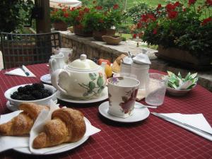维托里奥·威尼托Hotel Calvi-Ristorante Mainor的桌子,茶具,包括糕点和茶杯