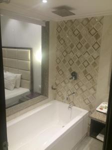 尼玛纳Shiva Oasis Resort的带浴缸和镜子的浴室