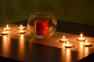 弗尔尼亚奇卡矿泉镇Love Apartment的木桌边带蜡烛的玻璃瓶