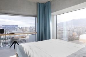 苏黎世苏黎世普莱西德设计与生活方式酒店的一间卧室设有一张床和一个大窗户