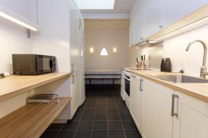 比伦德吉韦公寓的厨房配有白色橱柜、水槽和微波炉