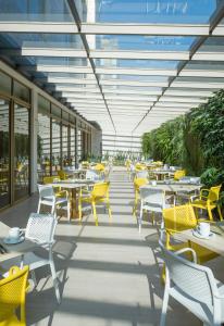波哥大波哥大理想国酒店的一间设有桌椅和黄色椅子的自助餐厅