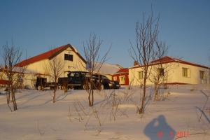 埃基斯蒂尔Country House Tokastaðir的停在房子前面的雪地里的卡车