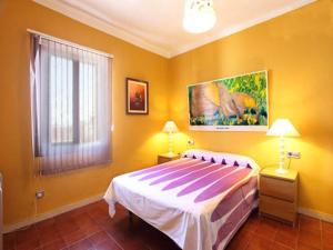 卡内·德·玛尔Beach Apartment Santissima的卧室配有一张床,墙上挂有绘画作品
