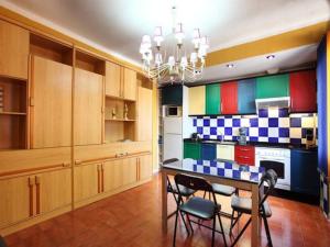 卡内·德·玛尔Beach Apartment Santissima的厨房配有色彩缤纷的橱柜和桌椅
