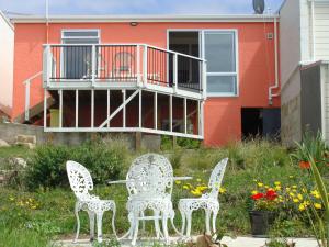 奥玛鲁奥马璐粉红色度假屋的房子前面的两把椅子和一张桌子
