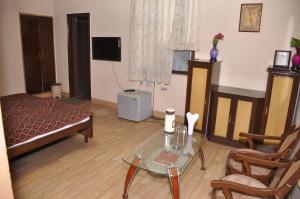 莫拉达巴德Hotel Pratiksha的客厅配有床和玻璃桌