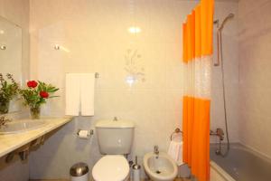 卡尼索肯尼科湾公寓酒店的浴室内配有橙色淋浴帘和卫生间