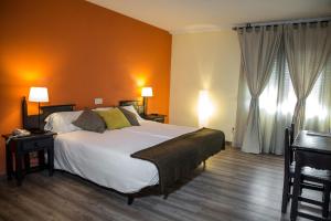 拉拉斯特里拉文塔玛谷罗酒店的一间卧室配有一张带橙色墙壁的大床
