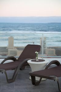 埃斯特角城Seaview Hotel Boutique的一个带两把椅子和一张桌子的庭院和大海