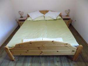 OplotnicaApartment Zeleni dragulj Pohorje的一张木床,房间有两个床头柜